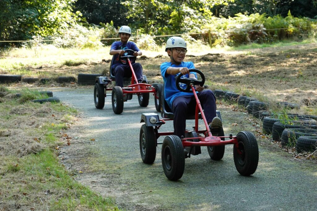 a picture of two students playing on go karts
