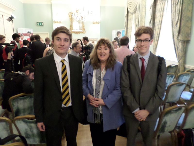 a picture of two students and a teacher at a debating event