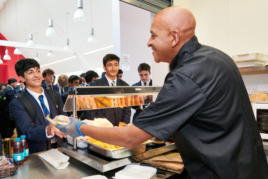 a picture of students getting food from the chef