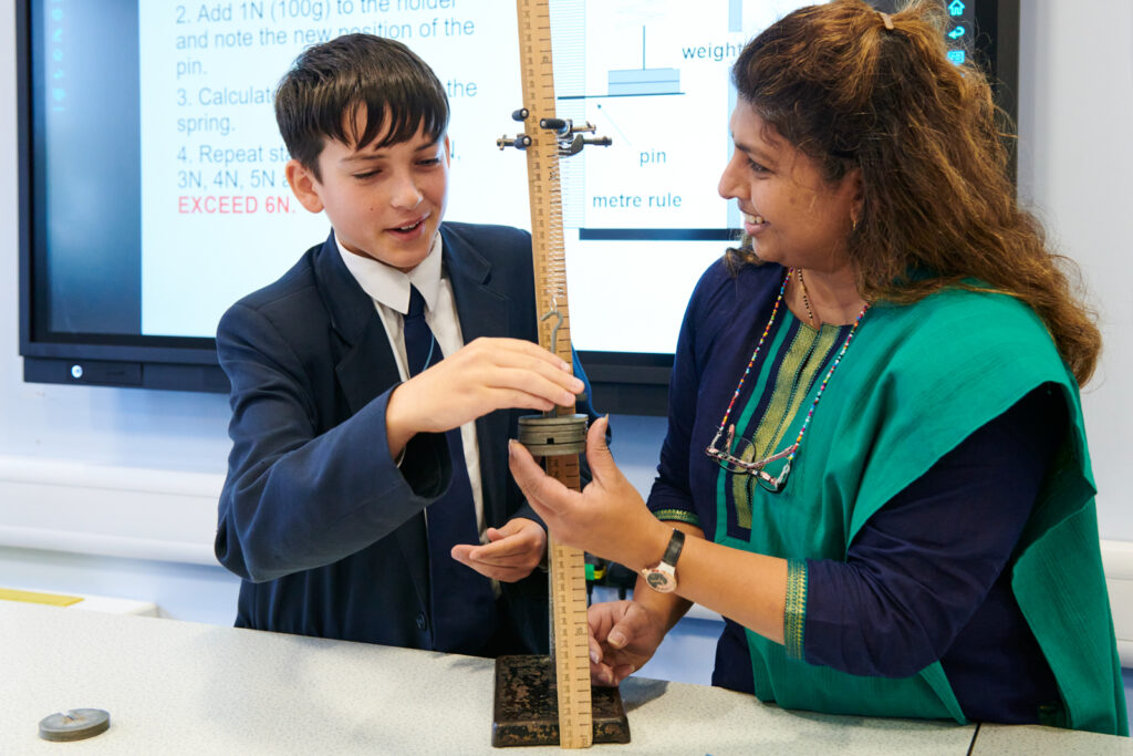 a picture of a student and a teacher doing an experiment