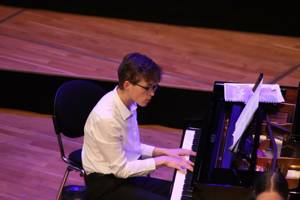a picture of a student playing a piano