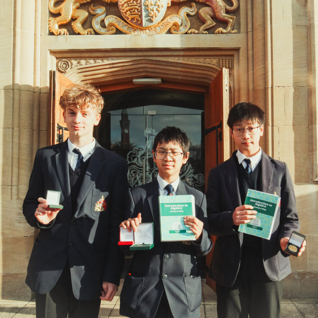 a picture of three students with awards