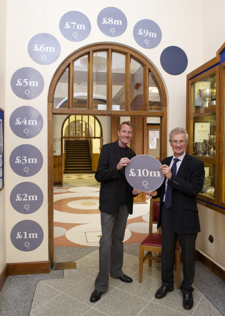 a picture of two people holdinjg the £10m sign