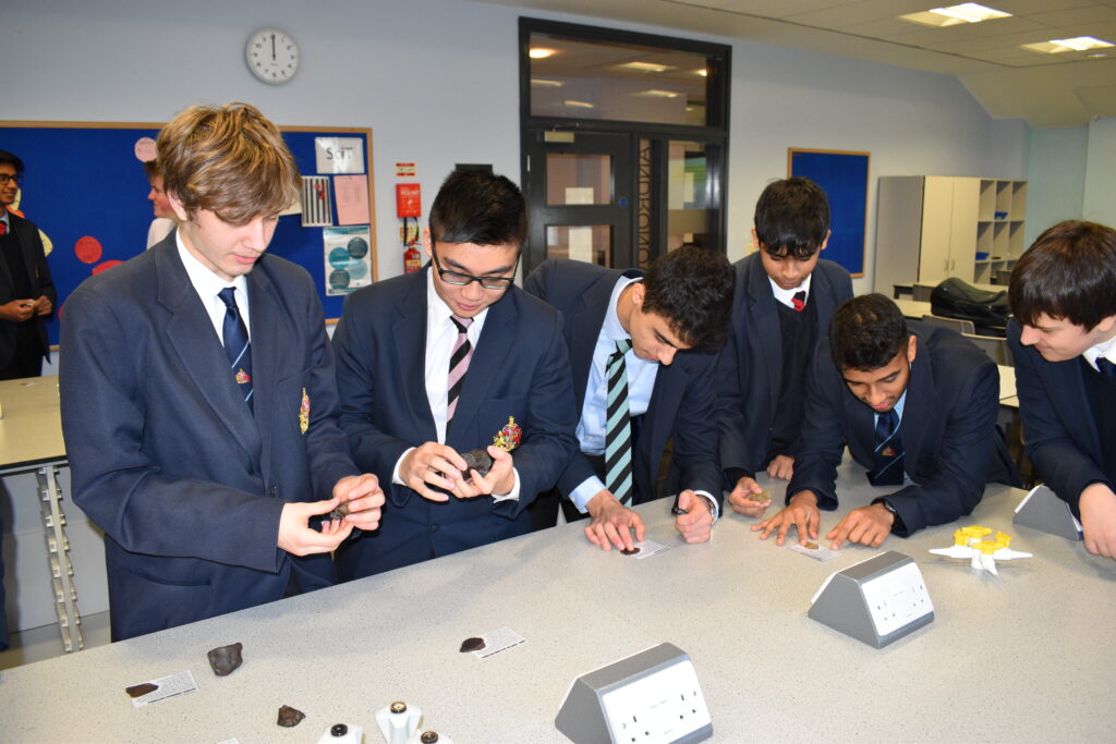 a picture of students looking at moon rocks