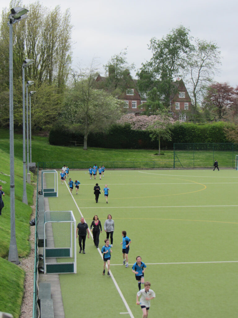 a picture of pupils and teachers on the astro turf