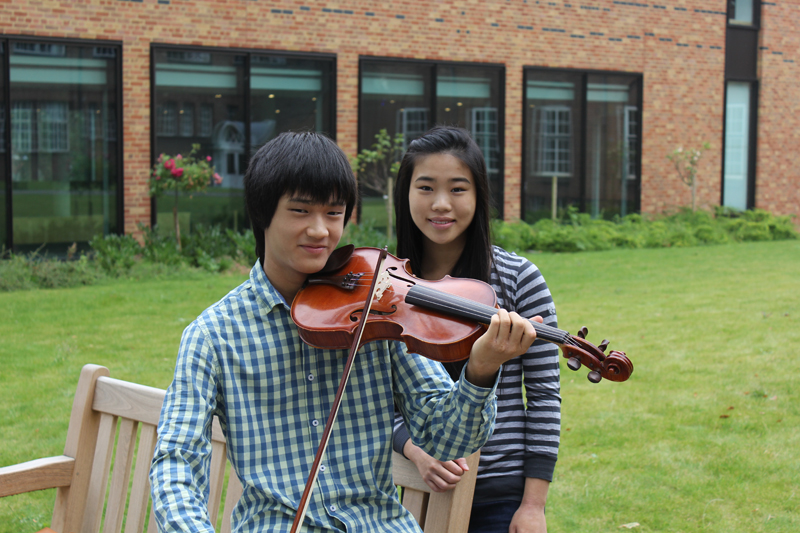 a picture of two sibling with a violin