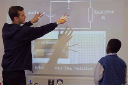 a picture of a teacher showing a students an equation on the board