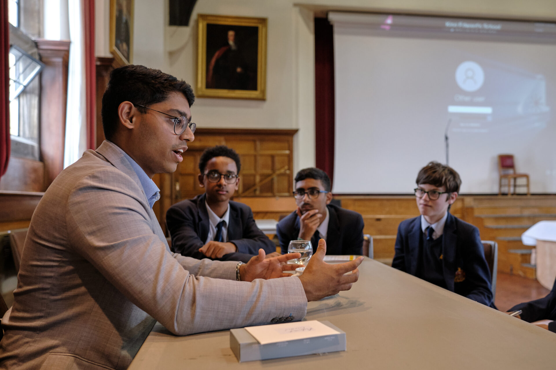 A group of pupils gathered around a table receiving careers advice from an King Edward's old boy.