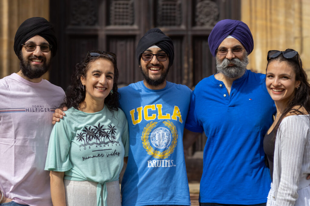 Five people are standing in front of a building.