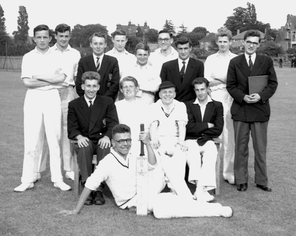 KES cricket team 1958. Some pupils standing and some seated. A mixture of those wearing whites and some with blazer and tie.